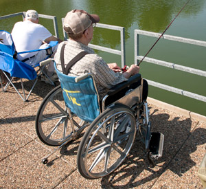 Man in wheelchair fishing on dock